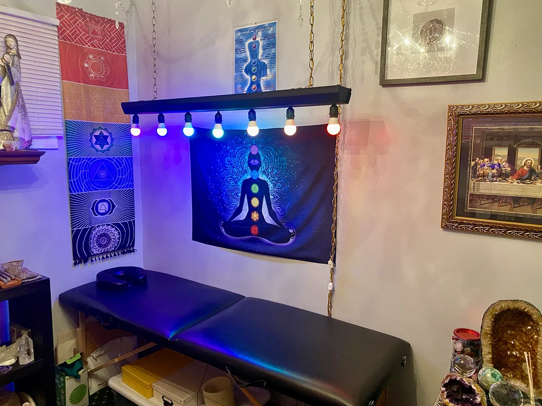 Mrs. Ames’s private chakra healing room in Gurnee, with a chakra tapestry, seven coloured lights and a treatment table